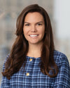Erin wearing a blue checkered jacket against a blurred background