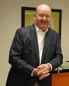 Tommy in a suit standing in an office setting